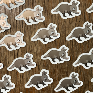 Zdjęcie przestawia naklejki z mrównikiem afrykańskim w uroczym stylu. Mrównik jest uśmiechnięty i mieni się delikatnie od światła.