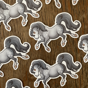 Zdjęcie przestawia duże naklejki z rozbrykanym, siwym konikiem zwróconym w lewą stronę. Konik jest maści siwej jabłkowitej i ma na sobie delikatne jasne serduszka.